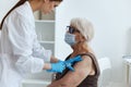 elderly woman wearing a medical mask syringe injection vaccine passport immunity protection Royalty Free Stock Photo