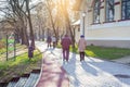 Elderly women and young couple walk along park path. One of the women using nordic walking poles. Nyiregyhaza, Hungary