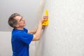 Elderly worker smoothing wallpaper