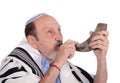 Eldery jewish man blowing the Shofar horn for Rosh Hashanah