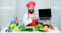 Elearning concept. Chef laptop read culinary recipes. Culinary school. Hipster in hat and apron learning how to cook Royalty Free Stock Photo