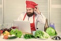 Elearning concept. Man chef searching internet recipe cooking food. Chef laptop read culinary recipes. Culinary school Royalty Free Stock Photo