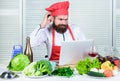 Elearning concept. Man chef searching internet recipe cooking food. Chef laptop read culinary recipes. Culinary school Royalty Free Stock Photo