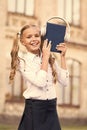 Elearning and modern methods. Girl cute schoolgirl hold book and headphones. Knowledge assimilate better this way. Audio