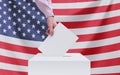 Election, America. Election concept. A hand throws a ballot into the ballot box. American flag on the background Royalty Free Stock Photo