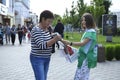 Election campaign. Girl campaigner giving leaflets to woman agitating for her party on a street