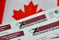 Election Canada voter information cards over small Canadian flag