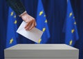 Election in EU. Voter holds envelope in hand above vote ballot.