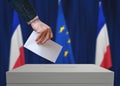 Election in France. Voter holds envelope in hand above vote ballot.