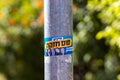 Election slogan on a Metal pillar, blurred background of trees