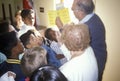 Election volunteers instructing young people on voting procedures in a polling place, CA