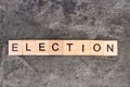 Election word written on wood block, on gray concrete background. Top view.