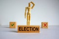 Election word written in wooden block. Wooden model of a man reflecting on a choice