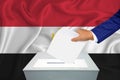 Elections in the country - voting at the ballot box. A man`s hand puts his vote into the ballot box. Flag Egypt on background Royalty Free Stock Photo