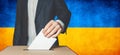 Elections in Ukraine, political struggle. Democracy, freedom and independence concept. Man Voter Putting Ballot In to Voting box Royalty Free Stock Photo