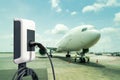 Electric aircraft charger station with plug and power cable supply on cargo or airplane parking with blue sky background