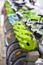 Electric bicycles with baskets for public rent stand in row on street of Paris awaiting cyclists Royalty Free Stock Photo