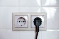 Electric black plug. Two sockets on a background of white tiles. Royalty Free Stock Photo