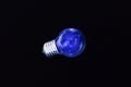 Electric blue light bulb on black background Royalty Free Stock Photo