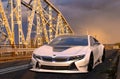 Electric BMW i8 Roadster on the old bridge during an evening storm Royalty Free Stock Photo