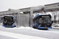 Electric bus at the charging station during recharging. Work in harsh winter conditions.