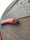 An electric cable of red-orange color in a section against the background of a wooden reel close-up. Multi-colored nine-hole cut Royalty Free Stock Photo