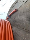 An electric cable of red-orange color in a section against the background of a wooden reel close-up Royalty Free Stock Photo