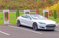 electric car being charged at Tesla Supercharger charging station in Fall
