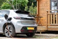 Electric car on charge at home green stripe on numberplate