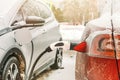 An electric car is charged from an electric charging station in winter. Eco transport. Transport on batteries Royalty Free Stock Photo