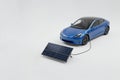 The electric car is charged from a solar panel. Space for text. Royalty Free Stock Photo