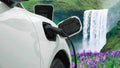 Progressive concept of energy sustainability by EV car in the waterfall.