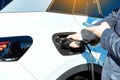 Electric car charging. Man`s hand inserting the electrical connector to the electric car. Royalty Free Stock Photo