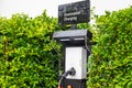 The electric car charging station in the middle of green trees symbolizes clean energy