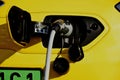 electric car charging station. yellow car detail with industrial grade cable and connecting plug closeup