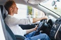 Electric car driver - green energy biofuel concept. Male behind wheel. Man driving new ecofriendly vehicle Young male owner proud Royalty Free Stock Photo