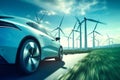 Electric Car Driving by Windmills on Country Road Royalty Free Stock Photo