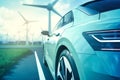 Electric Car Driving by Windmills on Country Road Royalty Free Stock Photo