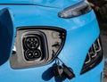 Electric car e-car Type 2 CCS charge socket on front of bright blue electric car ready to accept charge cable