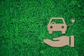 Electric car over business hand paper cut on green grass background with copy space , green energy iconic symbol Royalty Free Stock Photo