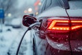 Electric car plug charging in the winter, rear view Royalty Free Stock Photo