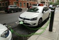 Electric cars charging their batteries parked along a busy street in London