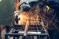 Electric circular grinder in metalwork factory. Worker cuts metal, close up. Sparks while grinding steel or iron parts