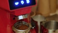 An electric coffee grinder grinds freshly roasted coffee beans into a filter holder Royalty Free Stock Photo