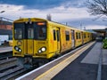 An electric commuter train at Hoylake Station on the Merseyrail rail transport network