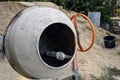 Electric concrete mixer on the background of a heap of sand. Construction machinery at the production site