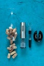 Electric corkscrew metallic gray color. Lies on a turquoise background. Nearby is a glass with corks, an aerator, a vacuum cork Royalty Free Stock Photo