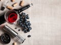 Electric corkscrew in steel gray. On a gray linen background. Near a glass, several corks, a bunch of grapes and a bottle of wine Royalty Free Stock Photo