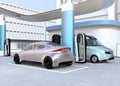 Electric delivery minivan and silver sedan charging at charging station