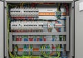 Electric distribution panel with multiple circuit breakers and organized wiring. Red, blue, and Royalty Free Stock Photo